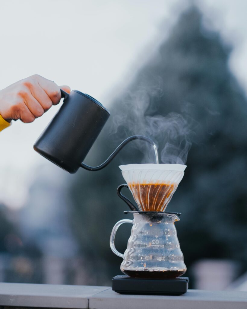 Close-up of Person Pouring Hot Water into a Coffee Pot with a Coffee Filter